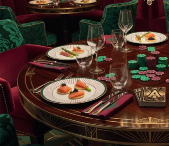 Stół z zielonym suknem, kartami do gry i żetonami obok eleganckich dań